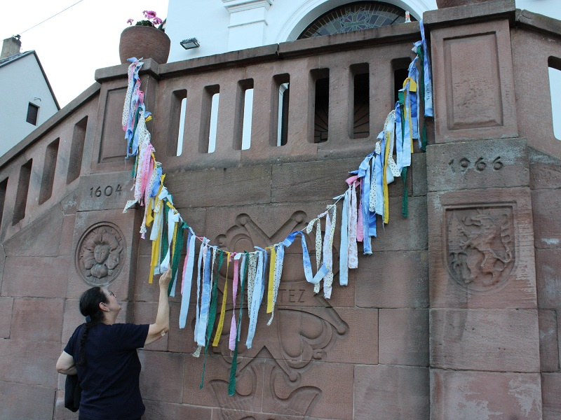 Die Gebetsbänder mit Wünschen für Frieden und Gerechtigkeit wurden an der Treppe der Hugenottenkirche aufgehängt, Fotos: evks/Eulenstein