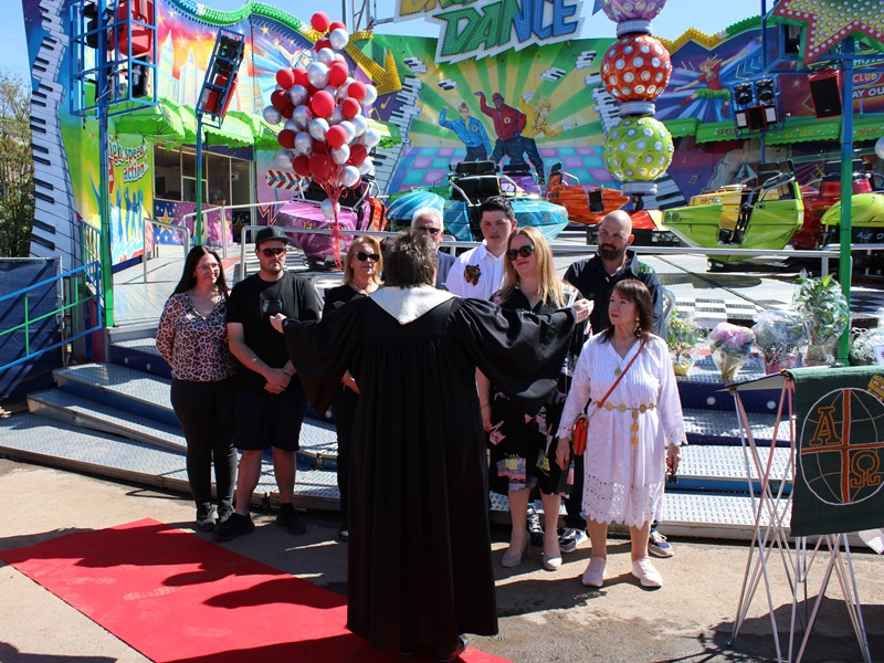 Schaustellerpfarrerin Christine Beutler-Lotz segnet die Betreiberfamilie des neuen Fahrgeschäftes 'Break Dance'